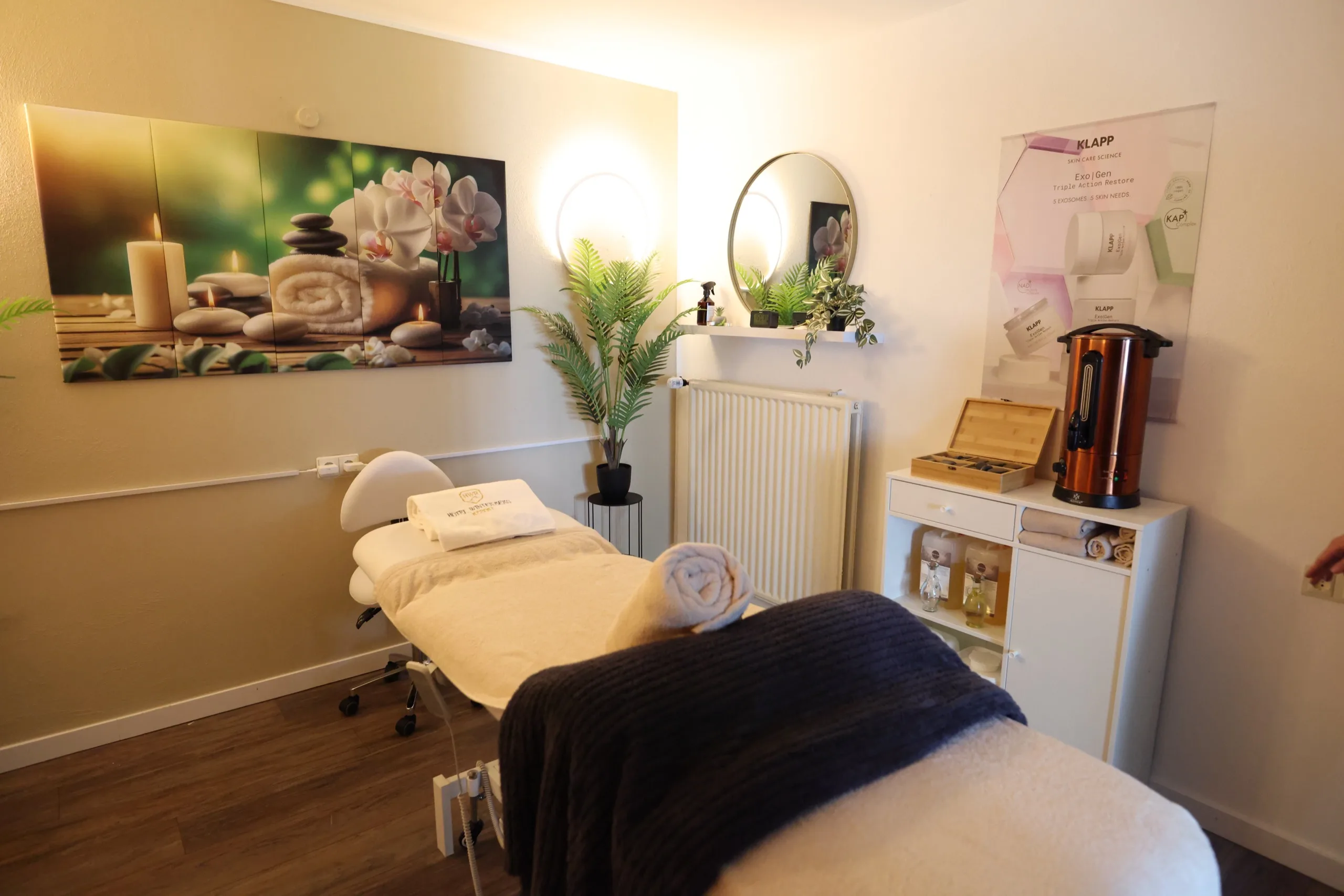 Spa treatment room with a prepared massage bed and warm lighting