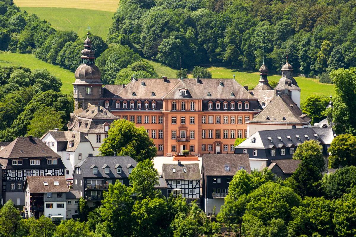Historische Schlossgebäude in einem bewaldeten Tal