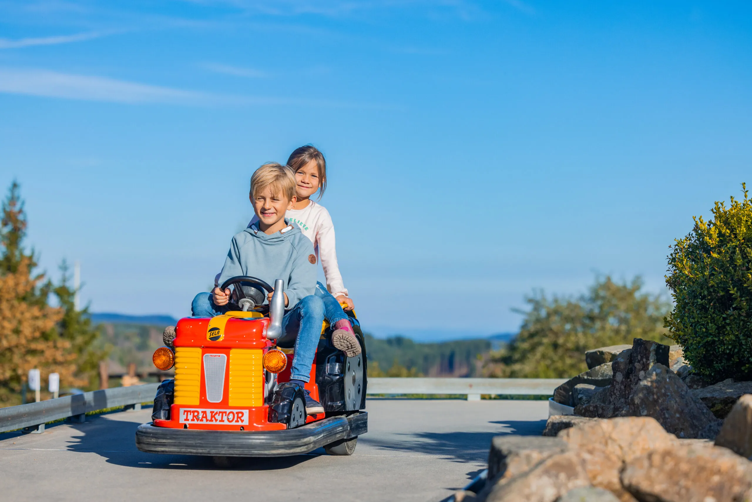 Kinder bei einer gemeinsamen Sommerrodelfahrt