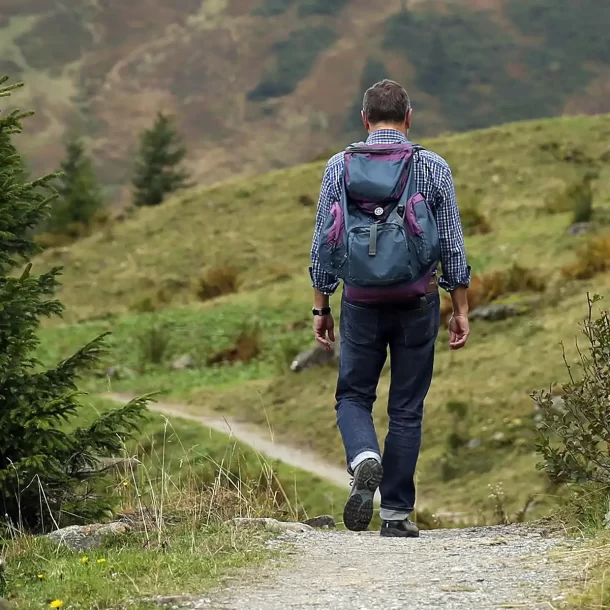 Hiker following a narrow hillside trail