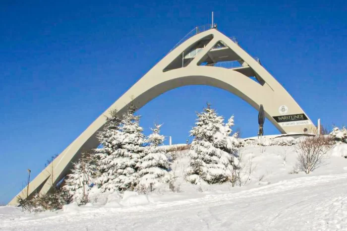 Verschneite Skisprungschanze unter blauem Himmel