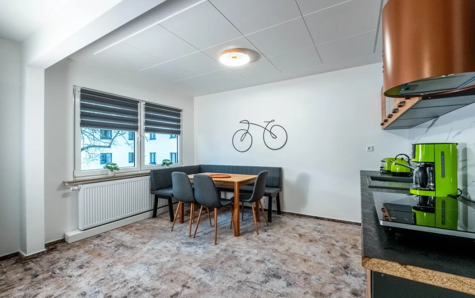 Eettafel naast een kitchenette met houten kasten