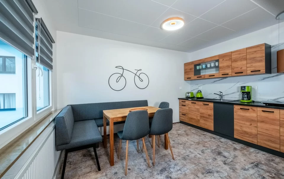 Eettafel naast een kitchenette met houten kasten