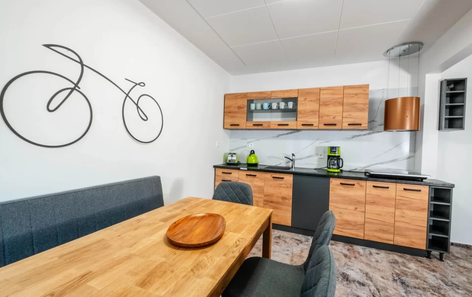 Eettafel naast een kitchenette met houten kasten