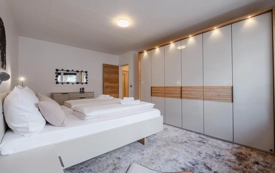 Tweepersoonsbed tegenover een grote inbouwkast
