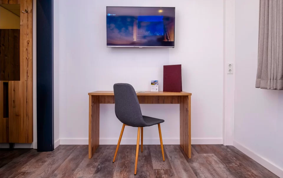 Bureau en stoel onder een televisie aan de muur