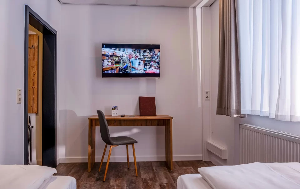 Bureau en stoel onder een televisie aan de muur