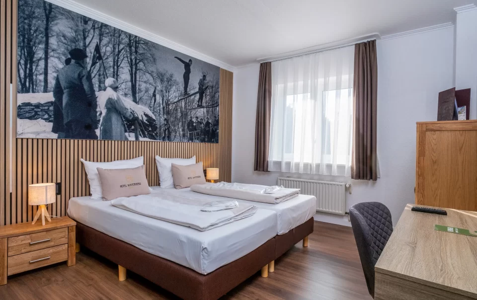 Tweepersoonsbed onder een grote winterlandschapsfoto