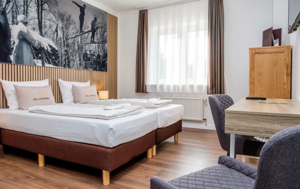 Tweepersoonsbed onder een grote winterlandschapsfoto