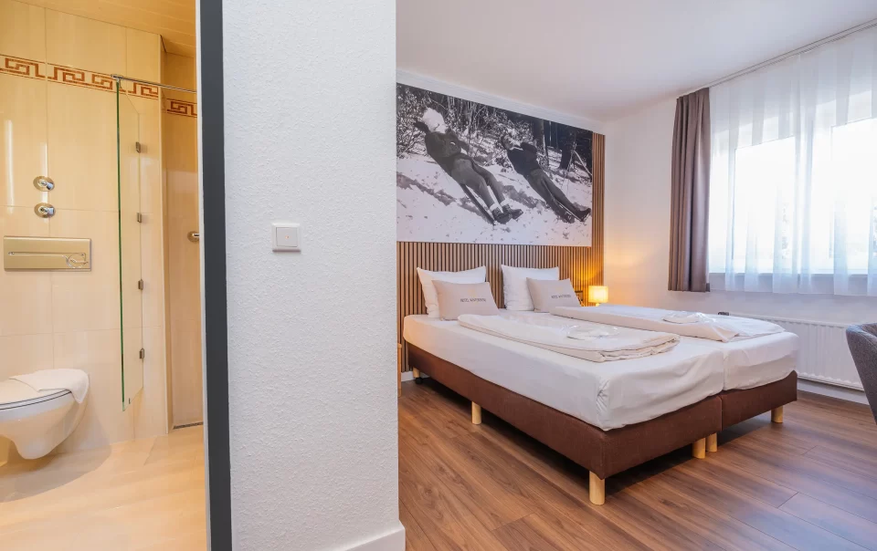 Tweepersoonsbed onder een grote winterlandschapsfoto