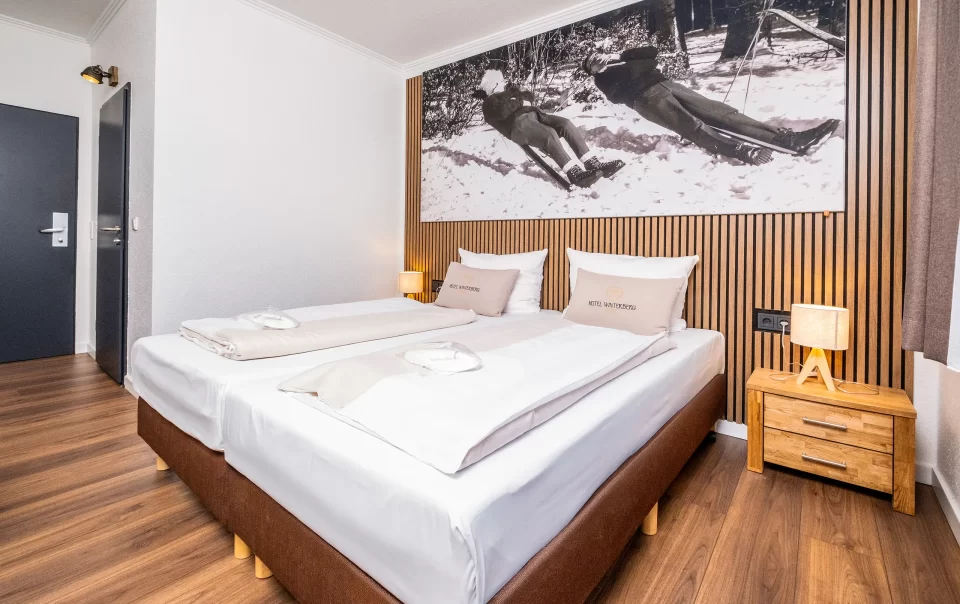 Tweepersoonsbed onder een grote winterlandschapsfoto