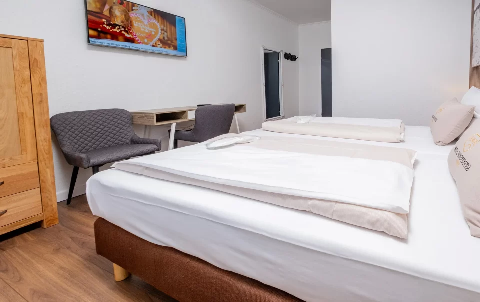 Tweepersoonsbed naast een zithoek