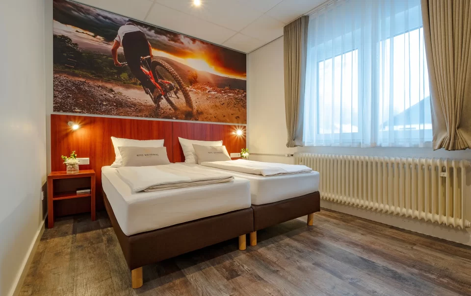 Tweepersoonsbed onder een wielerfoto