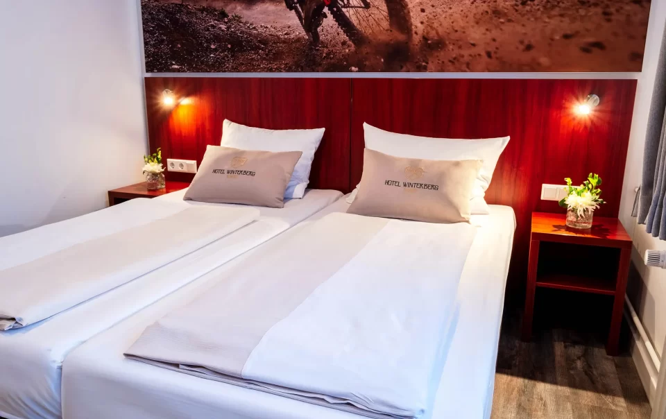 Tweepersoonsbed onder een wielerfoto