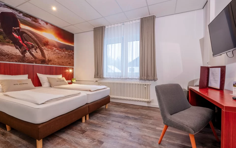 Tweepersoonsbed naast een zithoek