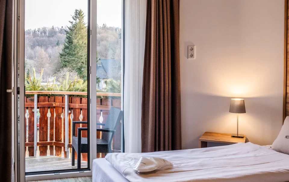 Double bed beside an open balcony doorway