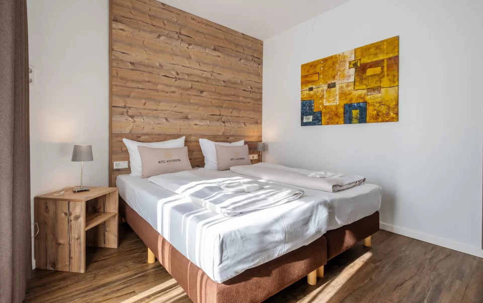 Double bed against a wooden feature wall