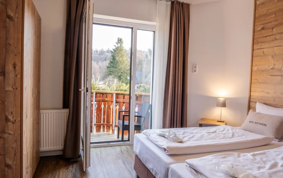 Double bed beside an open balcony doorway
