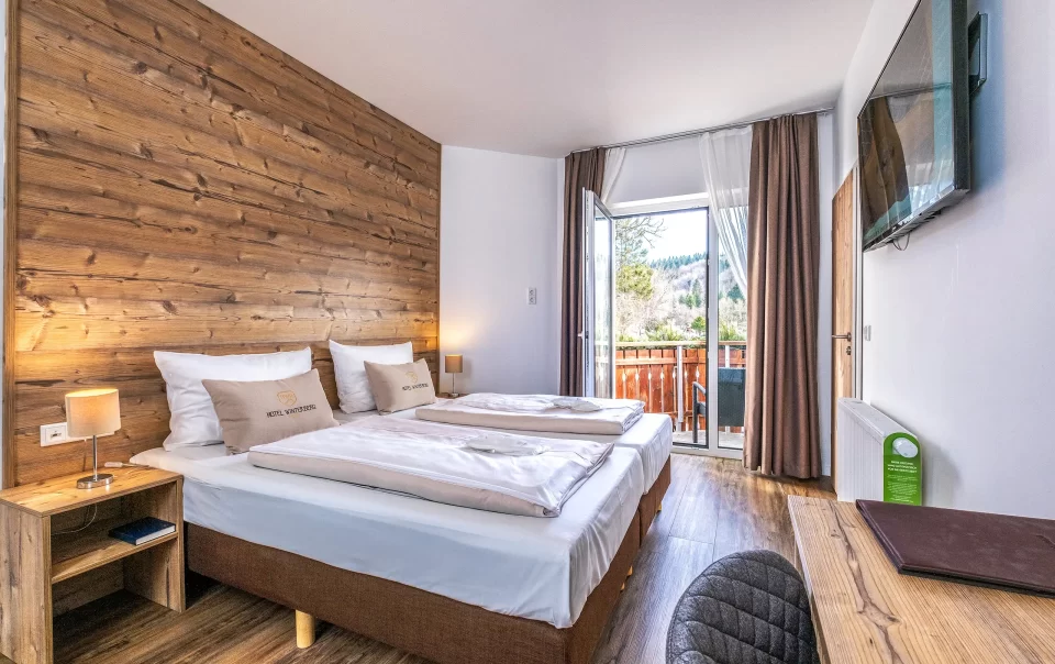 Double bed beside an open balcony doorway