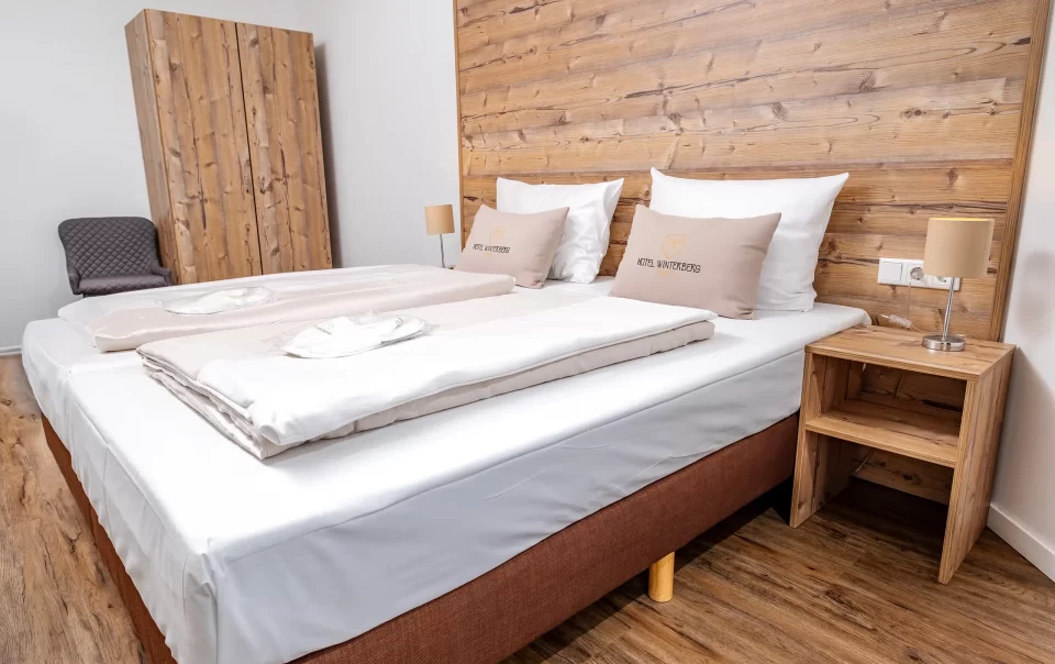 Double bed against a wooden feature wall