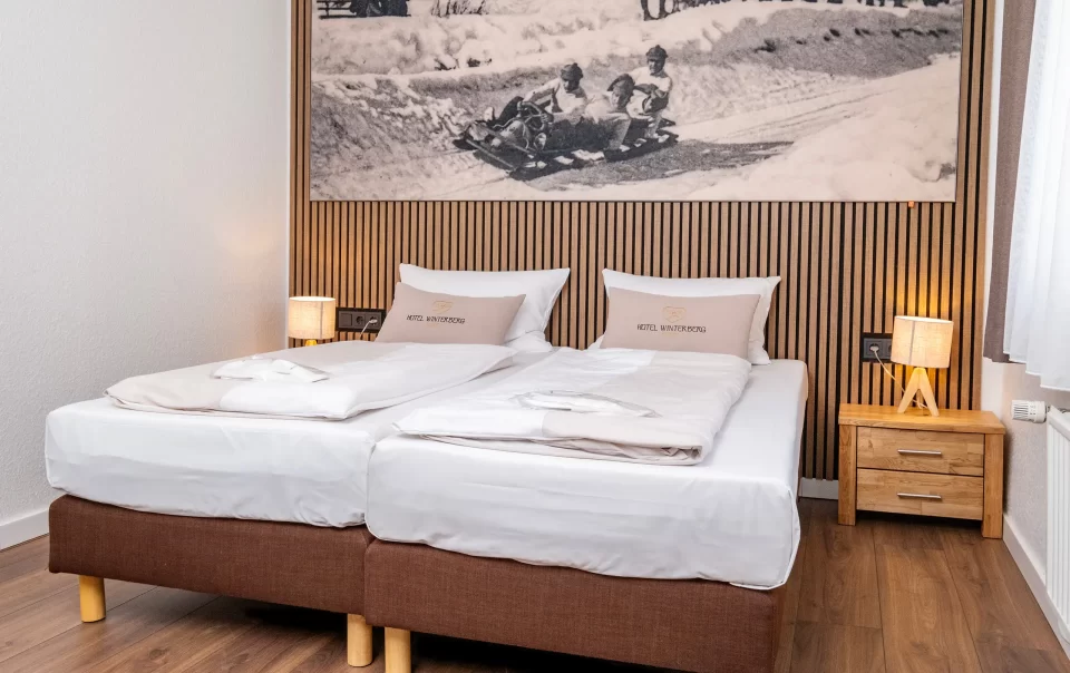 Double bed beneath a winter sports photograph
