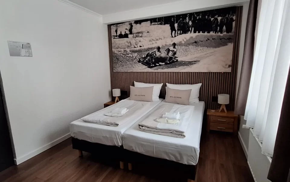Double bed beneath a winter sports photograph