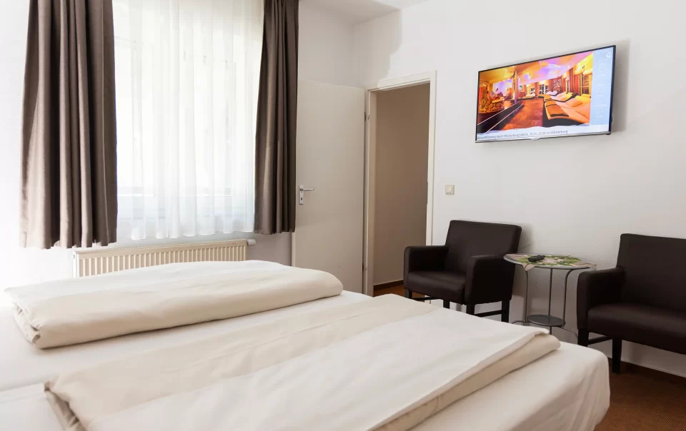 Beds beside a television and seating area