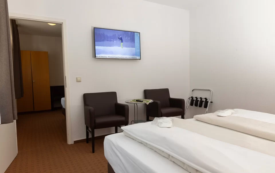 Beds beside a television and seating area