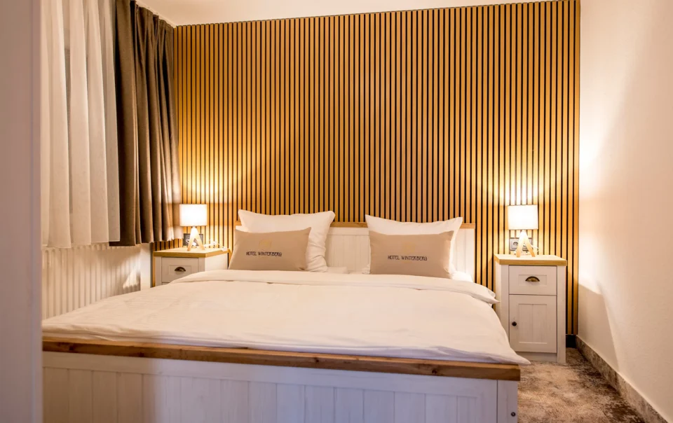 Double bed against a wood-panelled wall