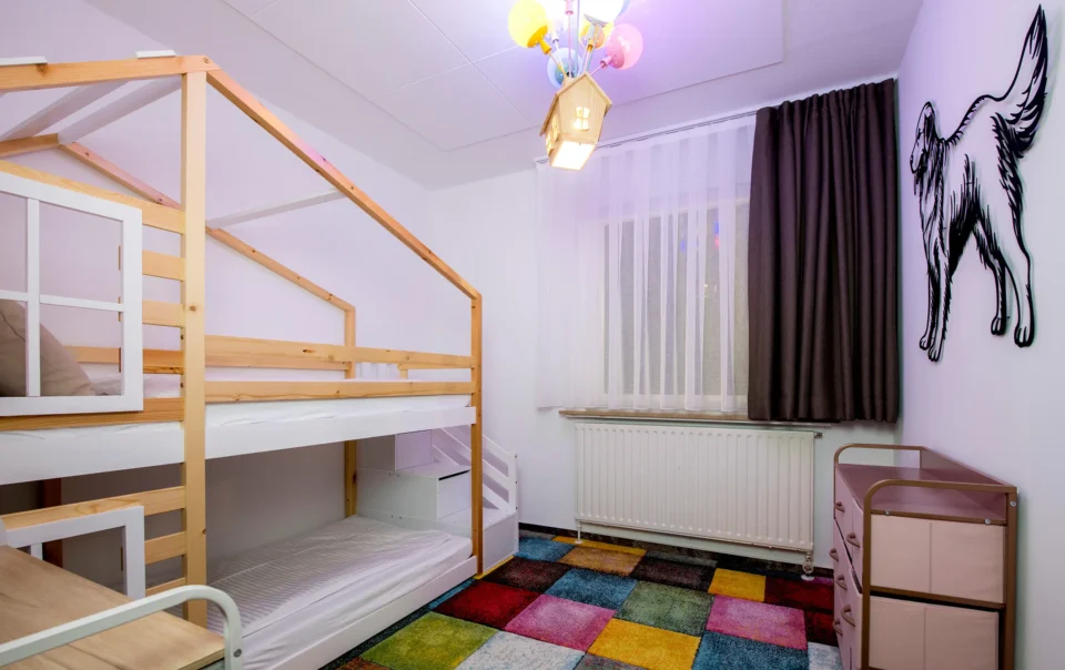 Children's bedroom with a wooden bunk bed and colourful rug