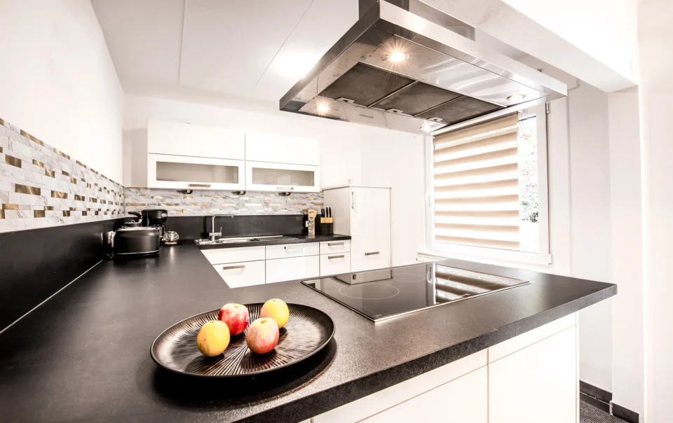 White kitchen with dark worktops and a cooking island