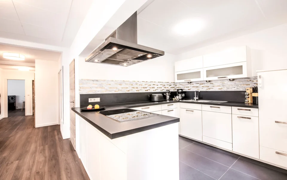 White kitchen with dark worktops and a cooking island