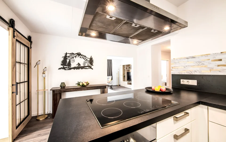 White kitchen with dark worktops and a cooking island