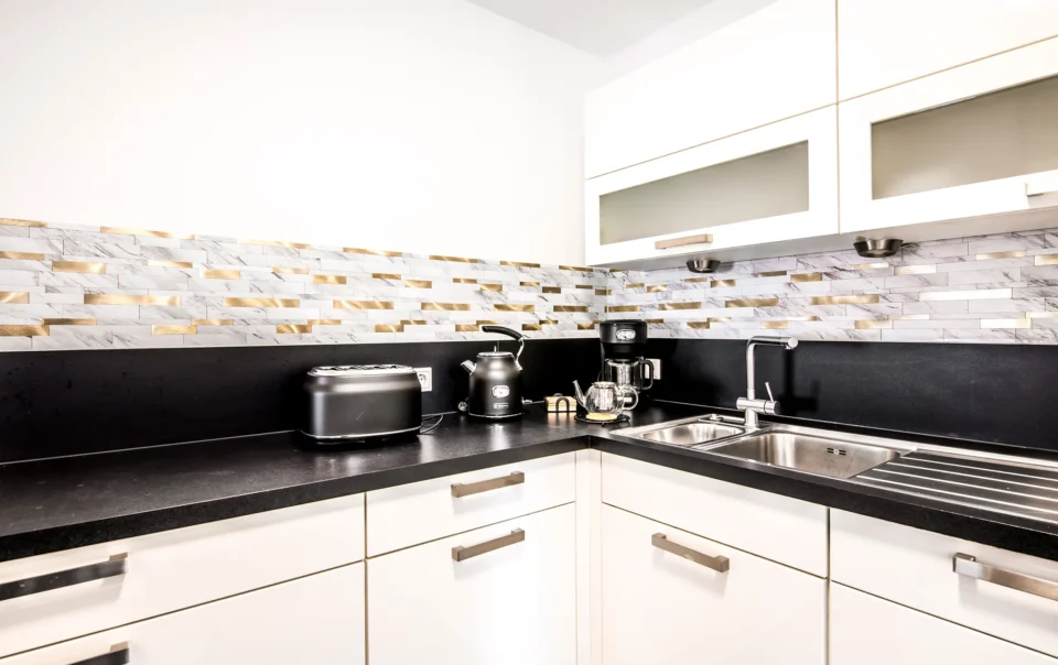 White kitchen with dark worktops and a cooking island