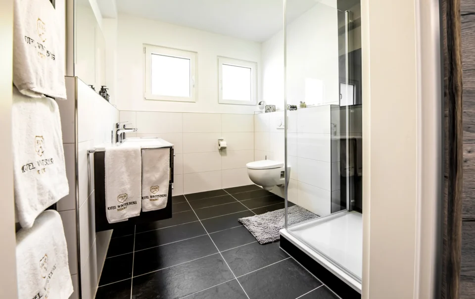 Bathroom with dark floor tiles and glass shower enclosure