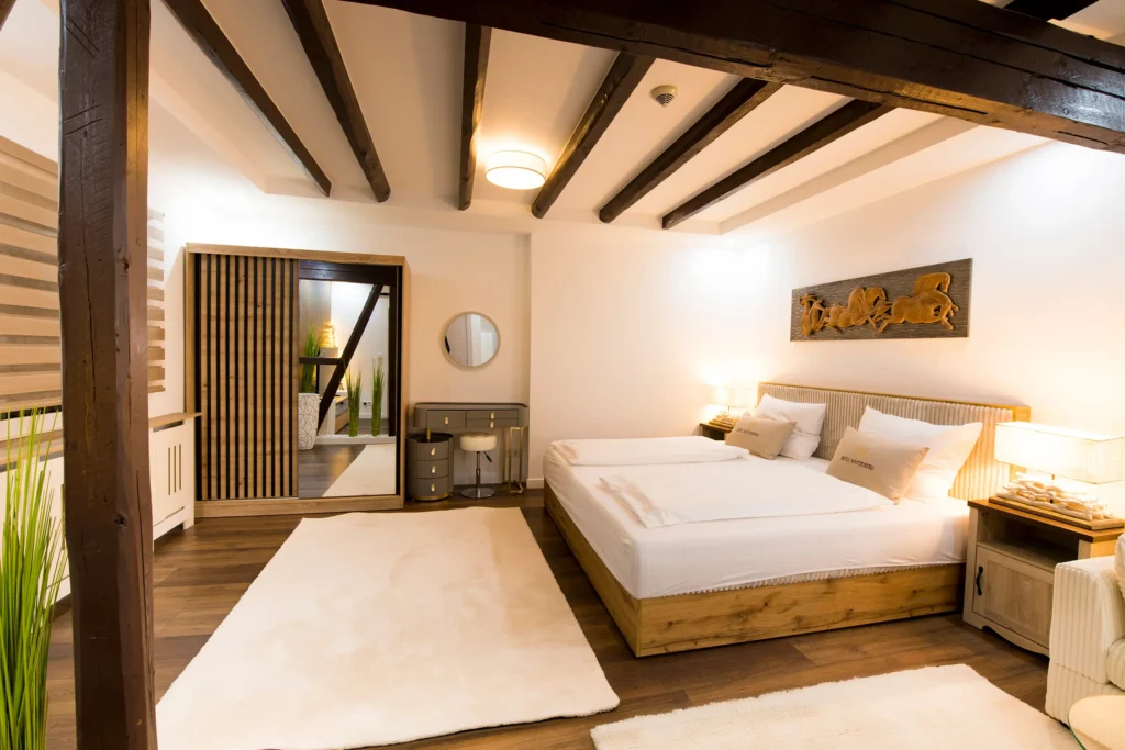 Suite bedroom beneath exposed wooden ceiling beams