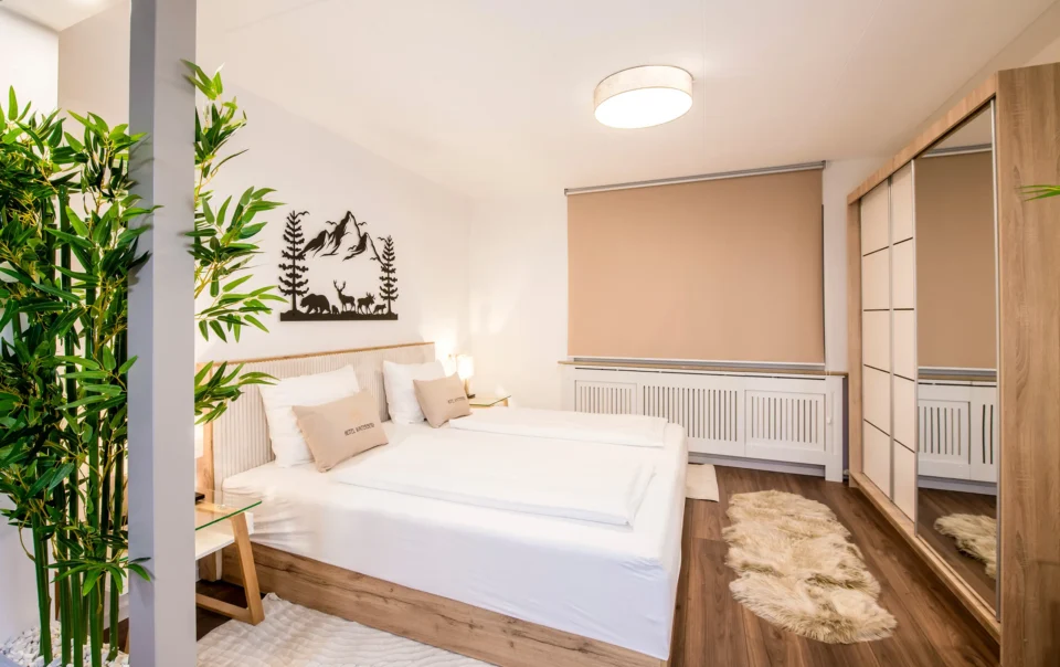 Double bed in an open suite with decorative greenery