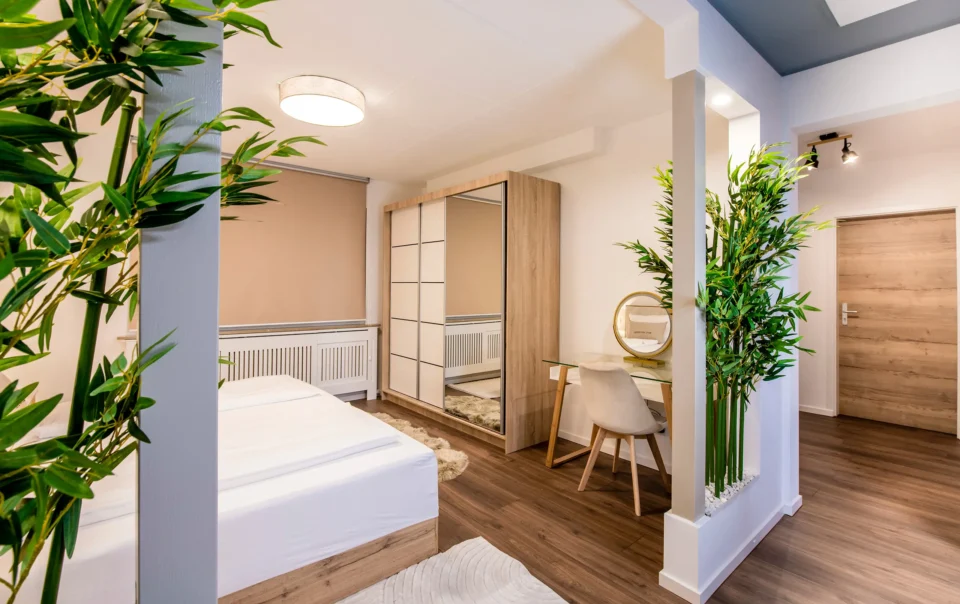 Double bed in an open suite with decorative greenery