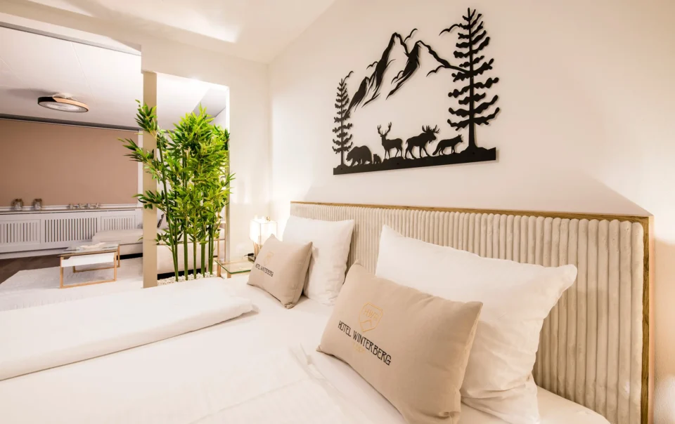 Double bed in an open suite with decorative greenery