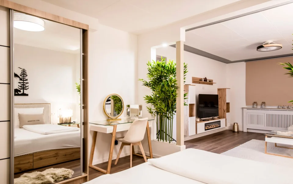 Double bed in an open suite with decorative greenery