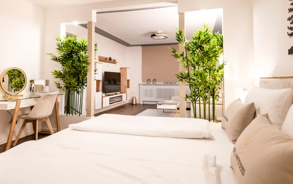 Double bed in an open suite with decorative greenery