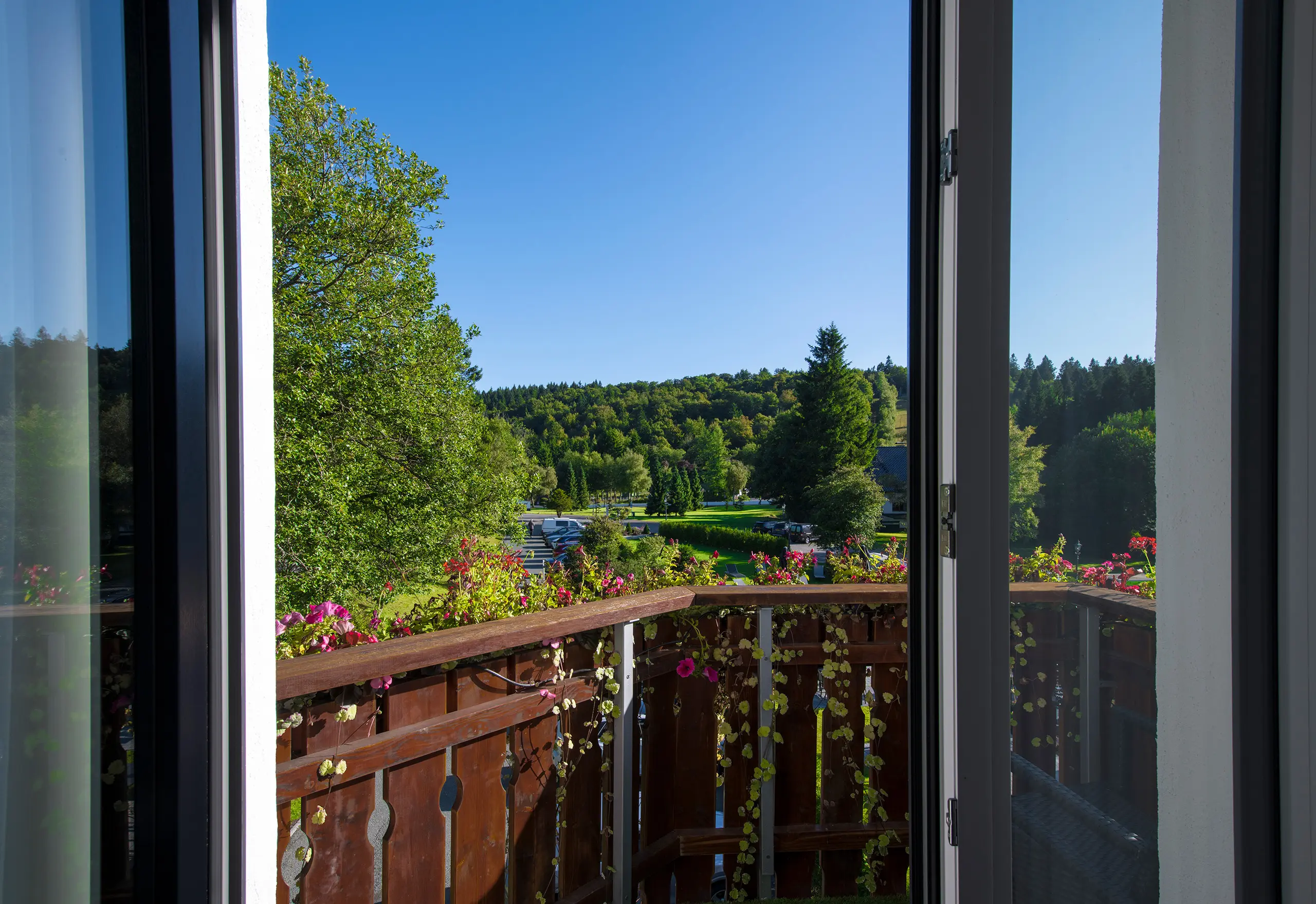 Blick vom Gästezimmer auf Balkon und grüne Hügel