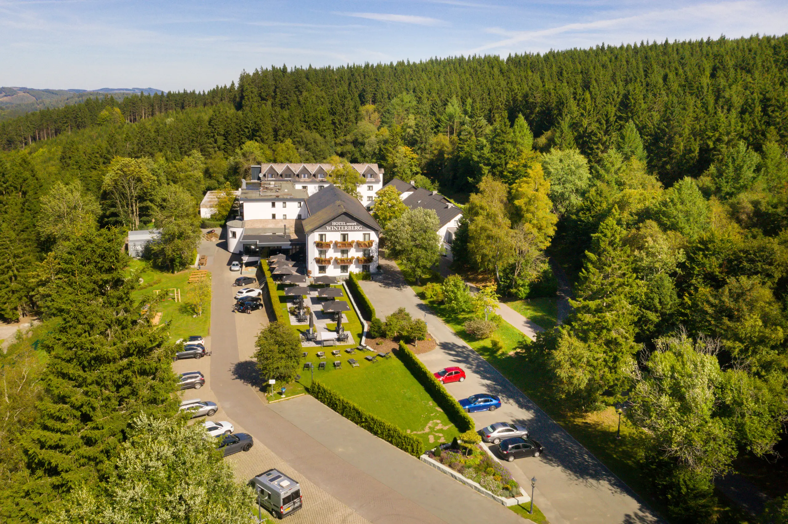 Luftaufnahme des Hotels und der umliegenden grünen Hügel