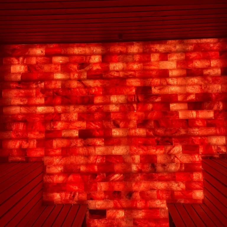 Illuminated salt-brick wall between wooden benches in the Himalayan salt sauna at Hotel Winterberg Resort.